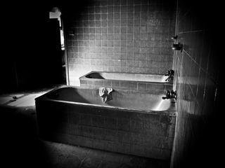 Illustration for article titled Photos of an abandoned asylum shot in black and white, complete with creepy mural